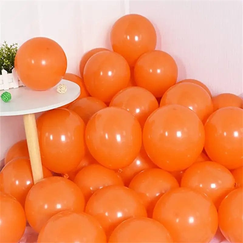 Orange 10 inch balloons in corner of room