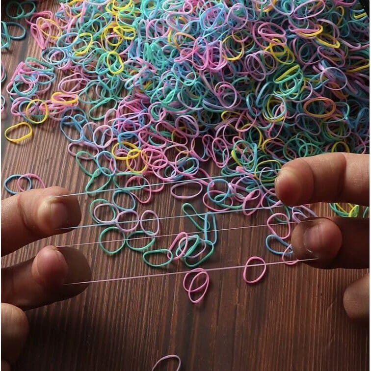colorful mini nylon hair ties being pulled by two fingers