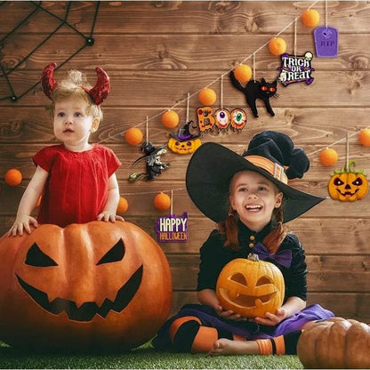 Halloween decorations hanging behind 2 girls in costumes 