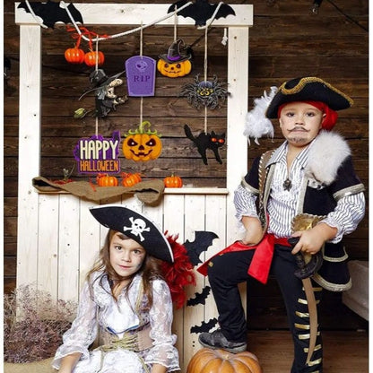 Halloween decorations hanging with 2 pirate kids under them