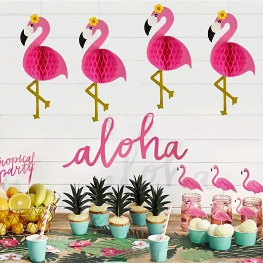 4 honeycomb hanging flamingos with Hawaiian theme décor around them