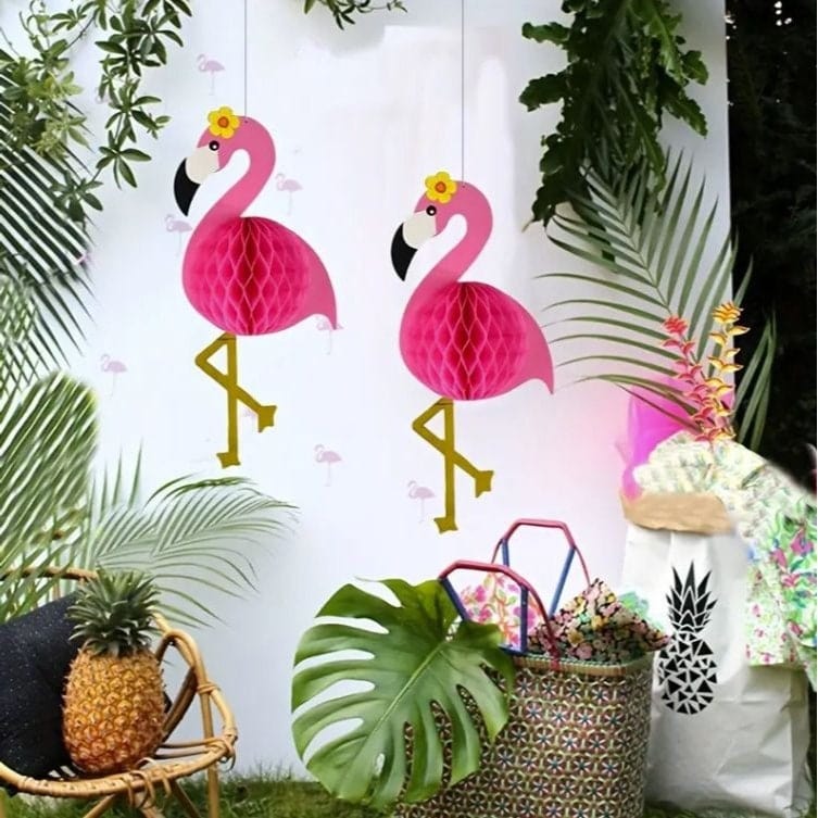 2  honeycomb hanging flamingos with Hawaiian theme décor around them