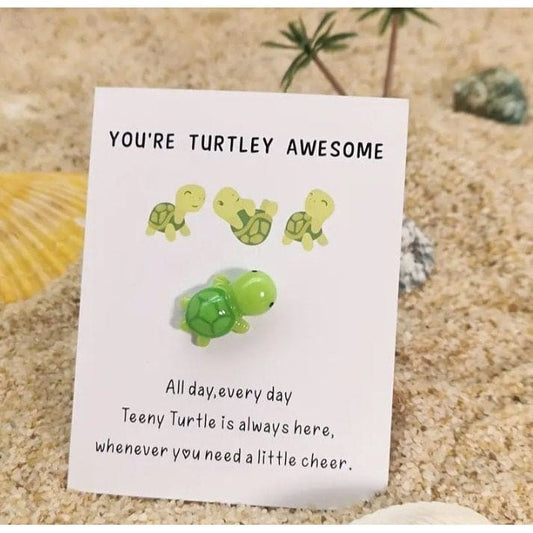 Turtle on card sticking in sand