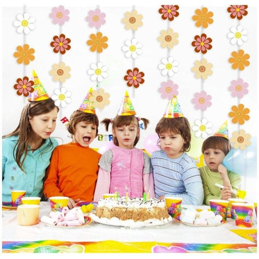 Birthday party celebration with groovy daisy garland as backdrop 