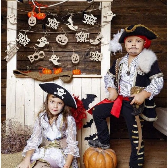 Boy and girl pirates with wooden Halloween decorations hanging