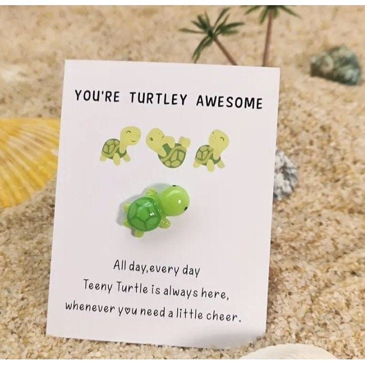 Turtle on card sticking in sand
