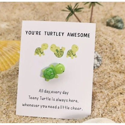 Turtle on card sticking in sand